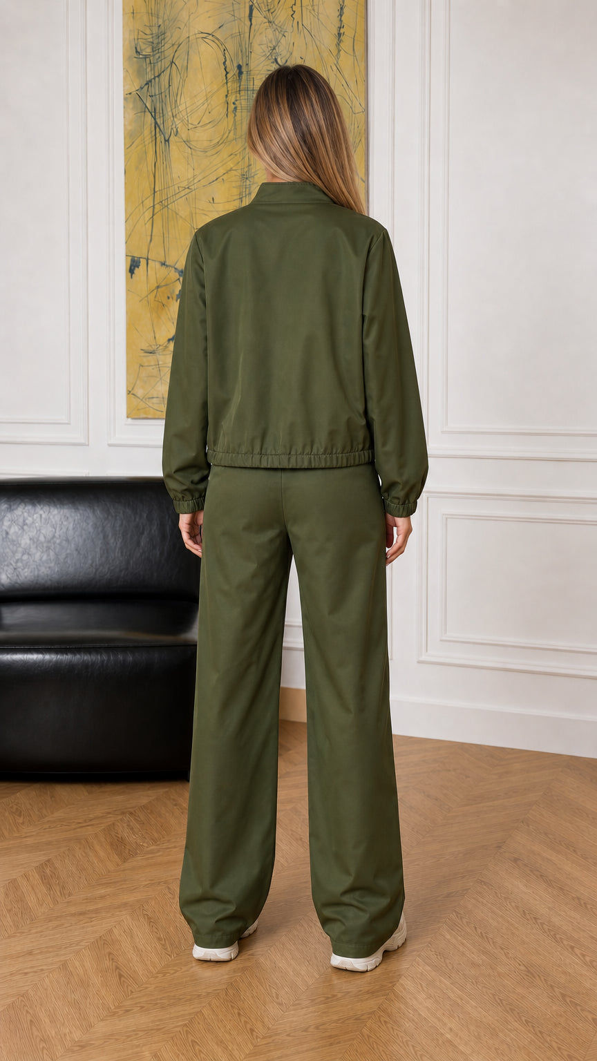 Back view of woman wearing the olive green zip jacket and wide-leg trousers
