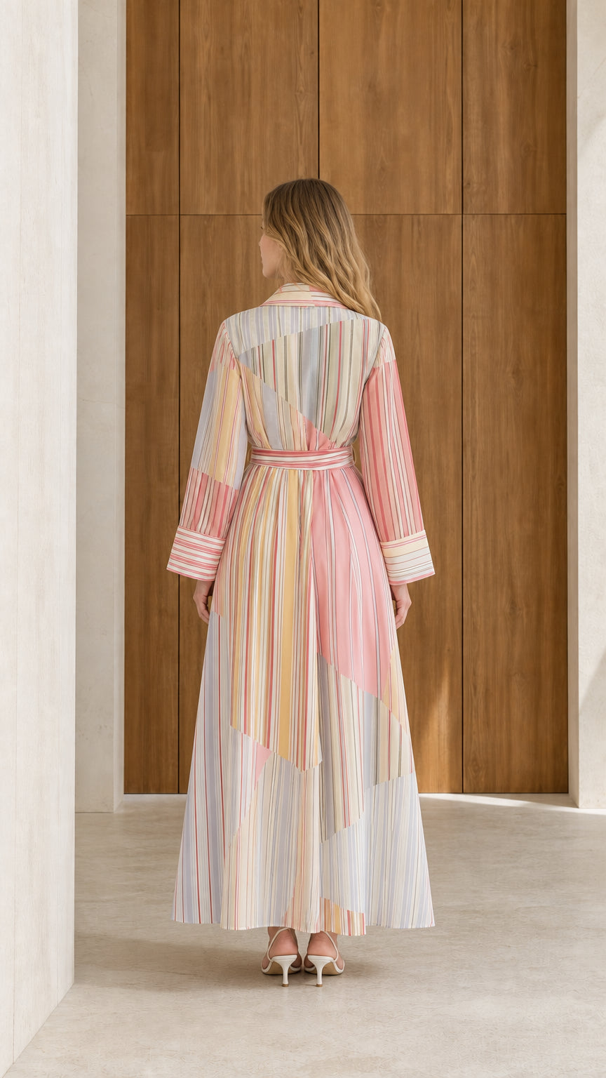 Back full-length view of model wearing pastel multi striped long sleeve maxi shirt dress