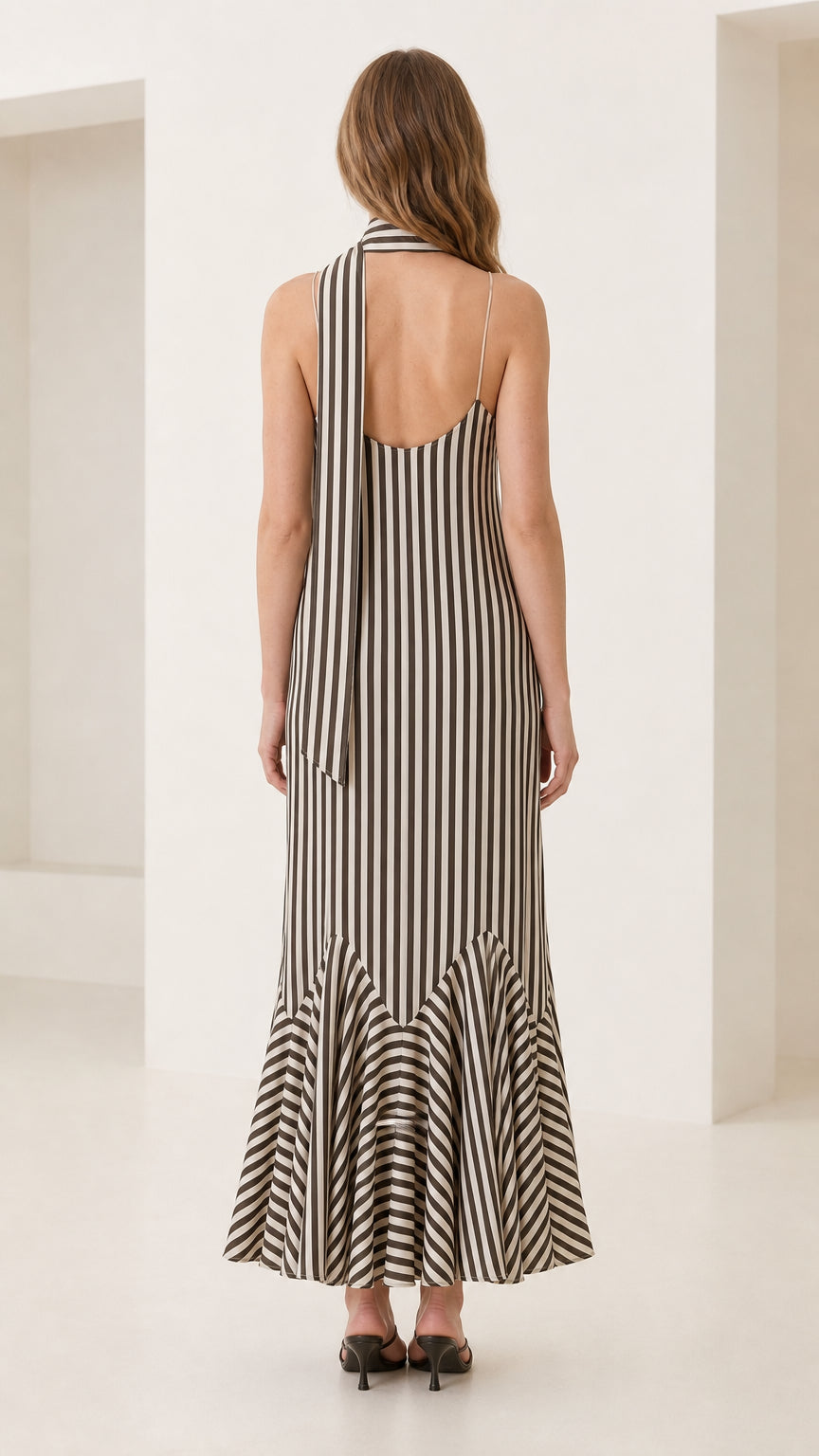 Back view of model showing long drape of the neck scarf and striped dress design