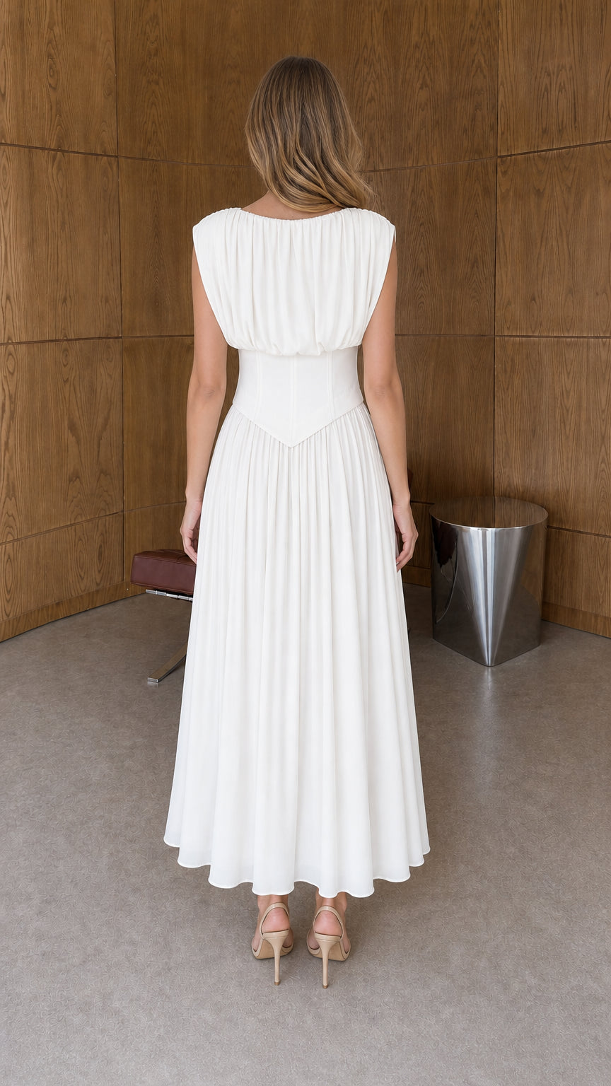 Back view of woman wearing white sleeveless draped bodice pleated dress