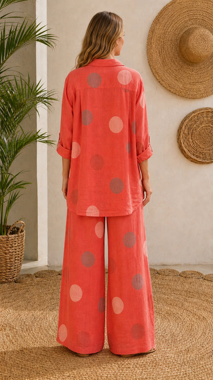 Back view of model wearing coral polka dot collared tunic and wide-leg trousers