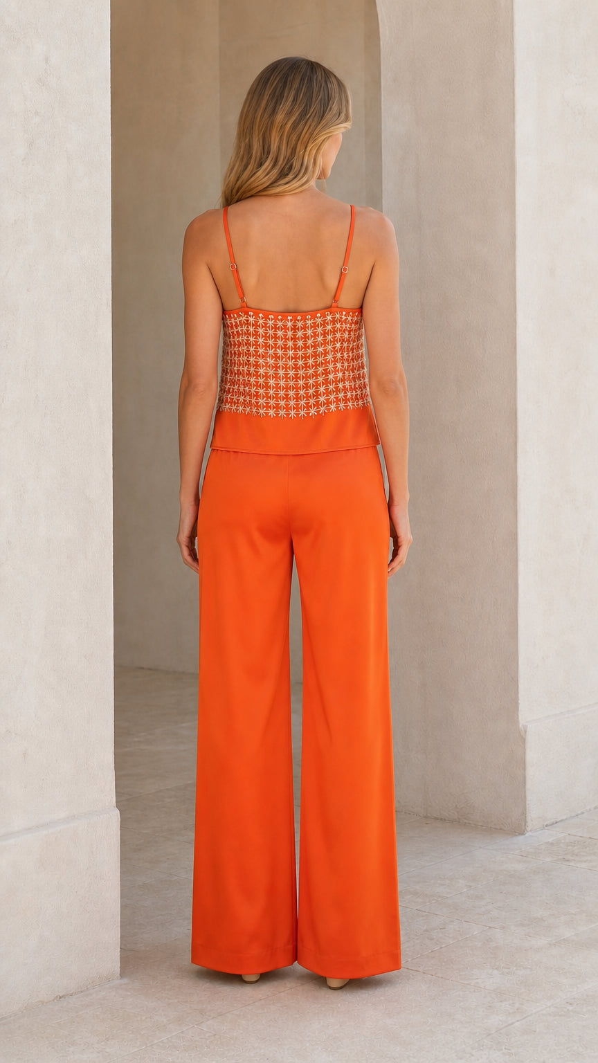 Back view of woman wearing orange cami and matching trousers