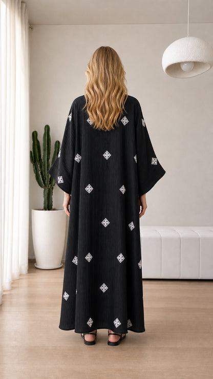 Back view of model wearing black textured embroidered maxi shirt dress