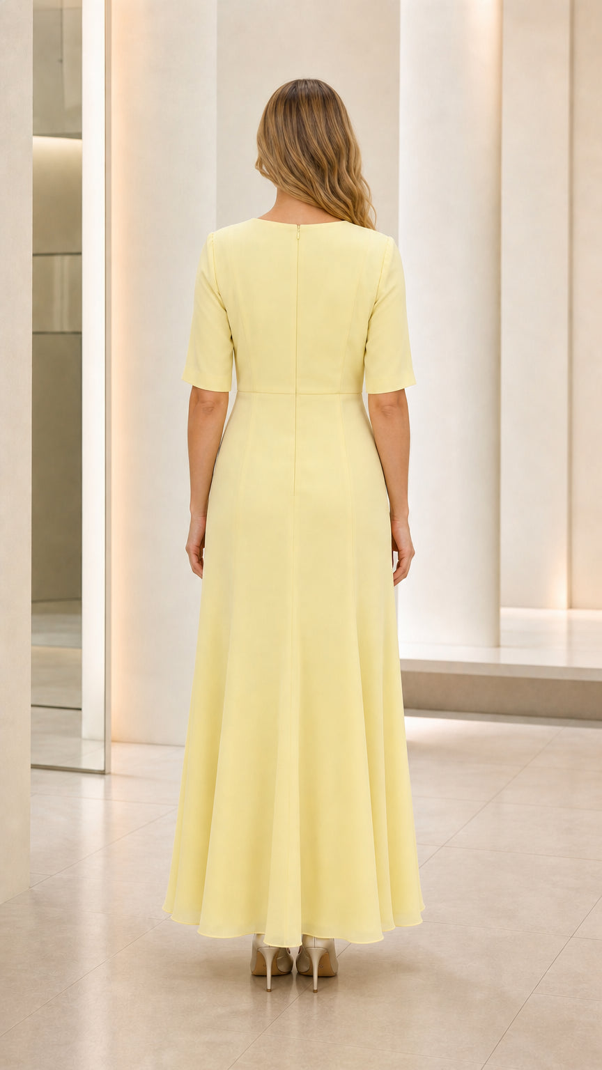 Back view of model wearing pastel yellow floor-length short sleeve formal gown