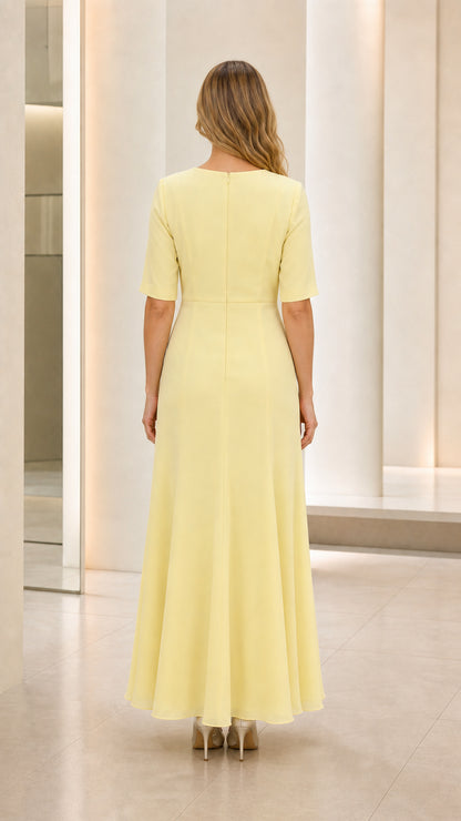 Back view of model wearing pastel yellow floor-length short sleeve formal gown