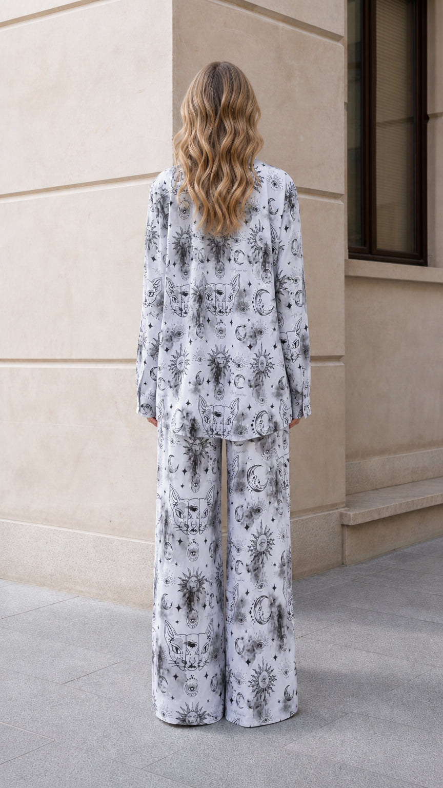 Back view of woman wearing white celestial sun and moon print pajama set