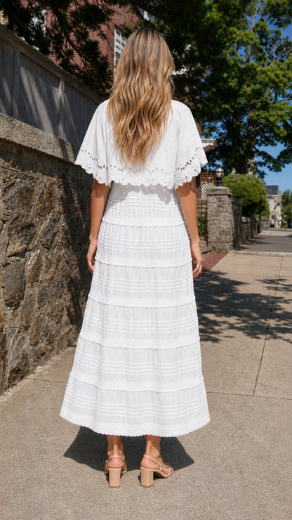 Back view of woman wearing white cape sleeve maxi dress