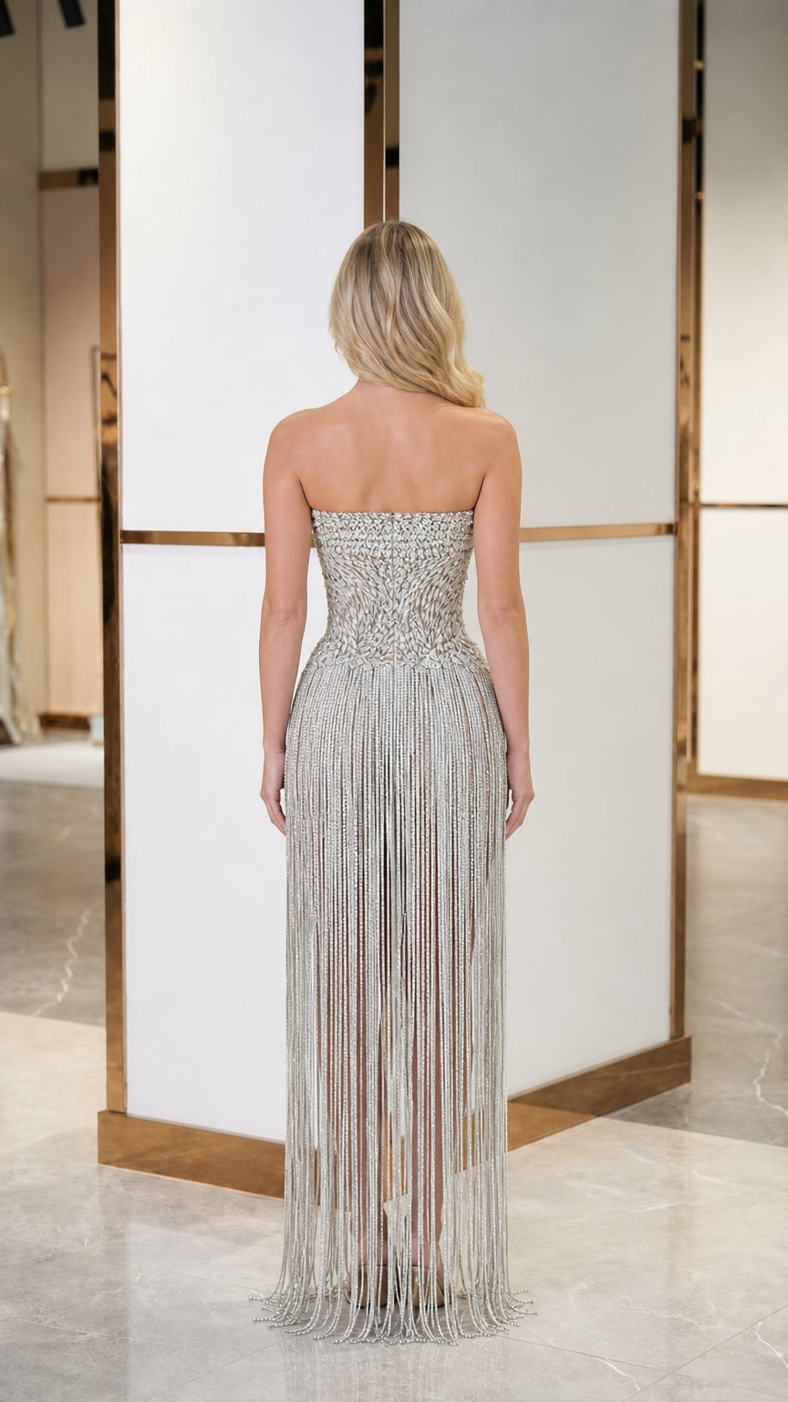 Back view of model showing intricate beading and fringe detail on gown