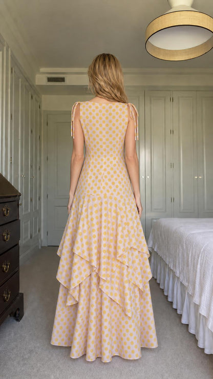 Back view of model in yellow polka dot tiered maxi dress