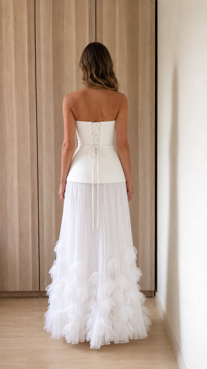 Back view of woman showing lace-up corset detail on white dress