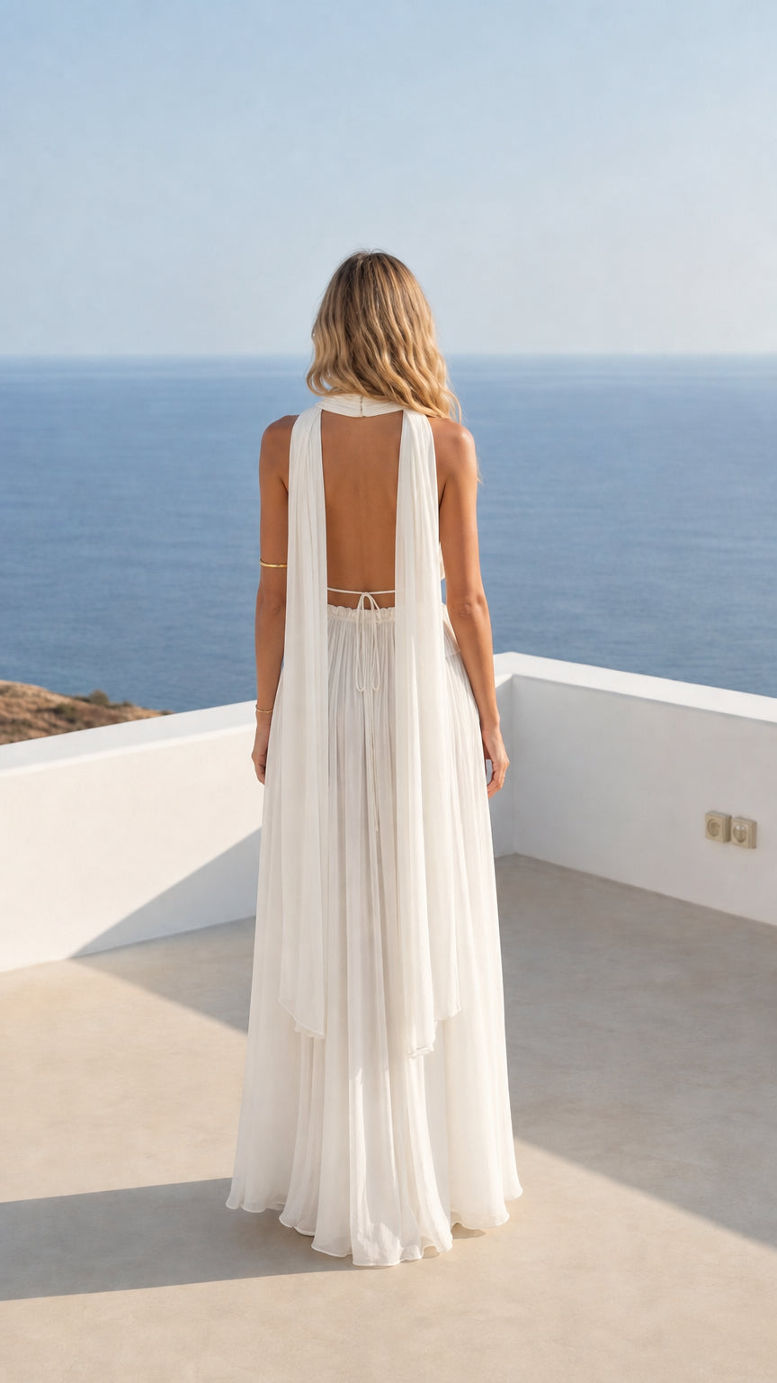 Back view showcasing open back design of white halter maxi dress