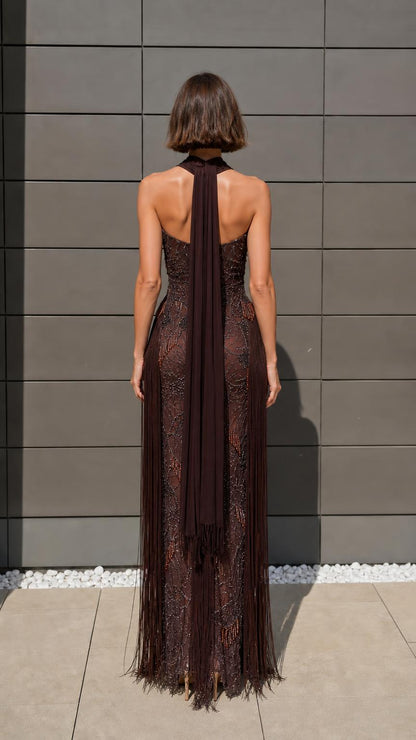 Back view of model showcasing long neck scarf and fringe details