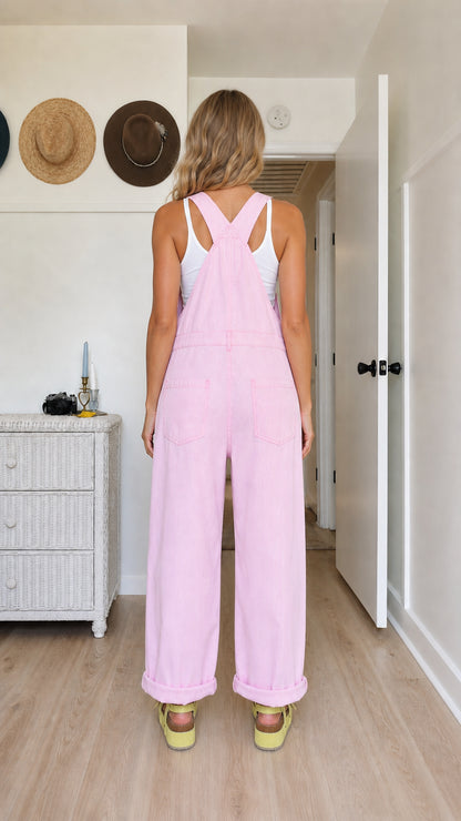 Back view of pink bib overalls showing crossed adjustable straps and full-length legs