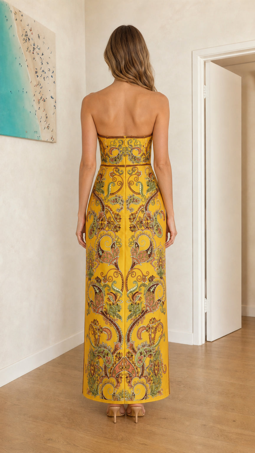 Back view of model wearing yellow paisley strapless maxi dress