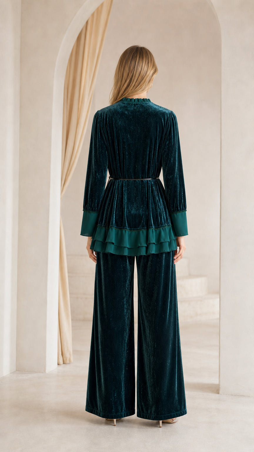 Back view of woman in dark green crushed velvet matching two-piece set