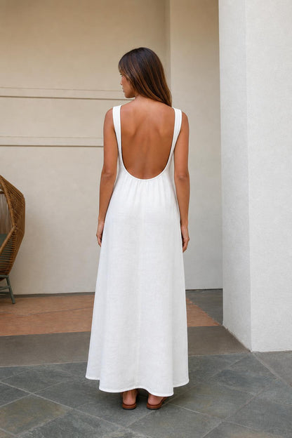Back view of woman wearing white maxi dress highlighting low scoop back