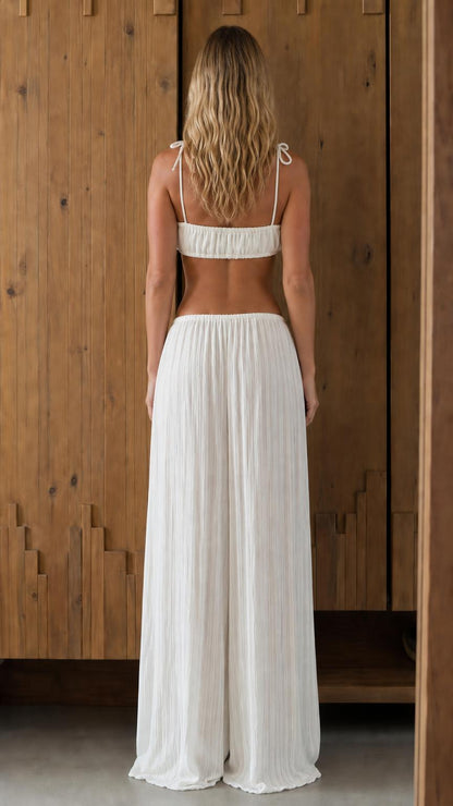 Back view of woman in white crop top and pants