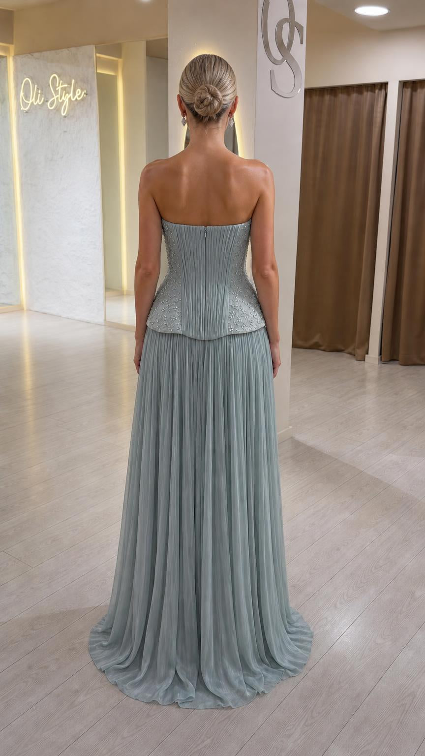 Back view of sage green formal dress showing structured bodice and pleated skirt