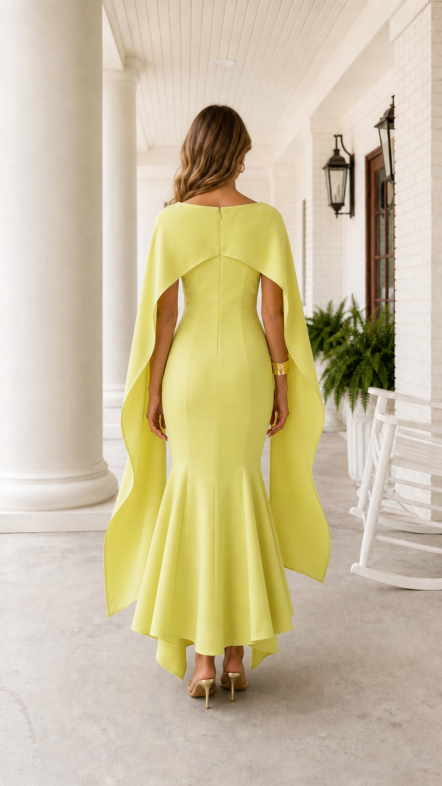 Back view of lime yellow floor-length mermaid gown showing draped cape design