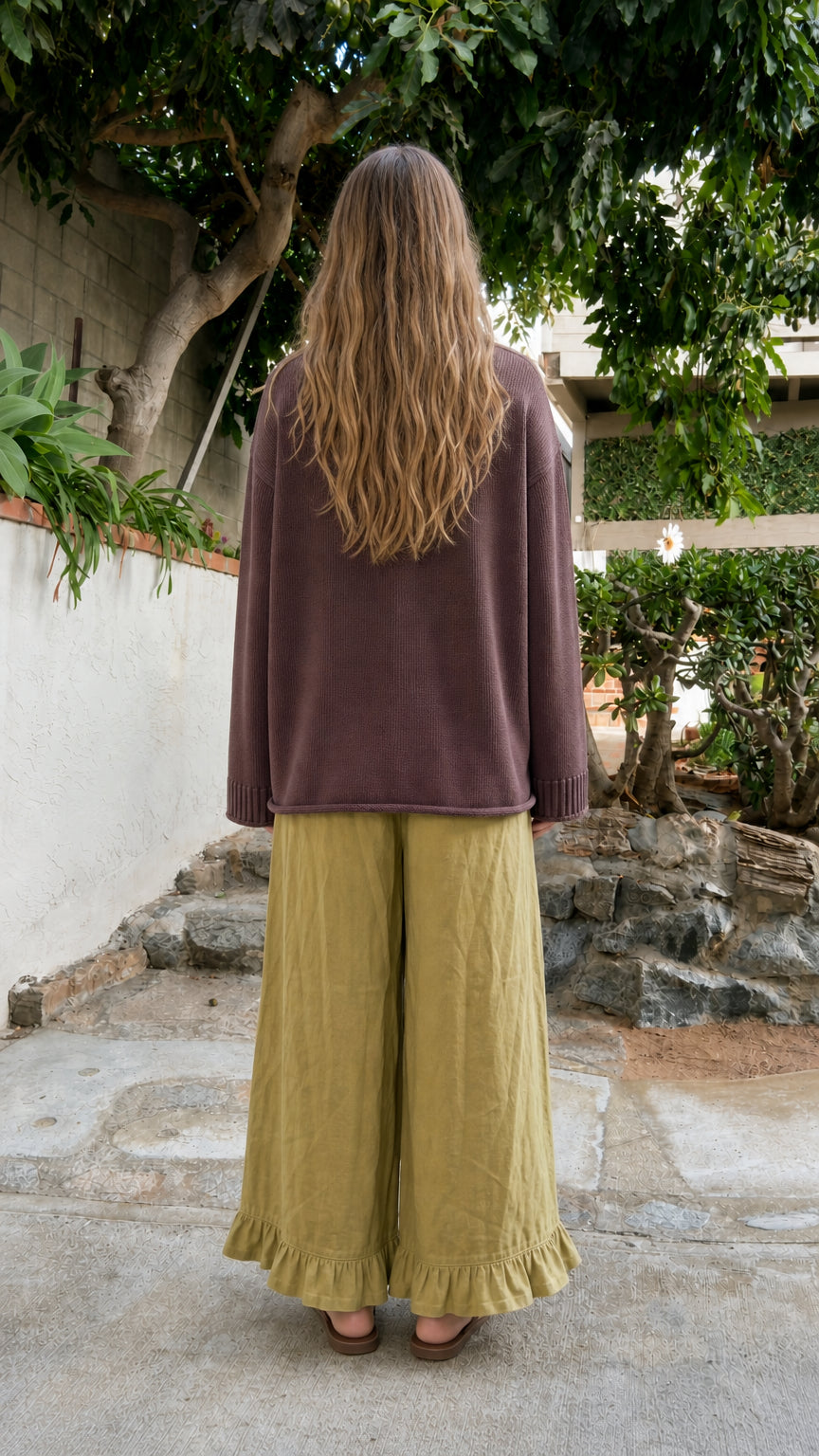 Back view of model wearing relaxed Brown crewneck knit sweater
