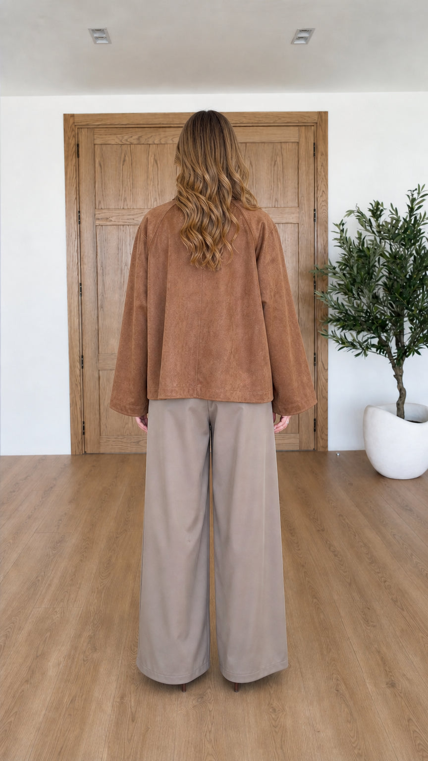 Back view of woman wearing relaxed Camel faux suede wrap jacket