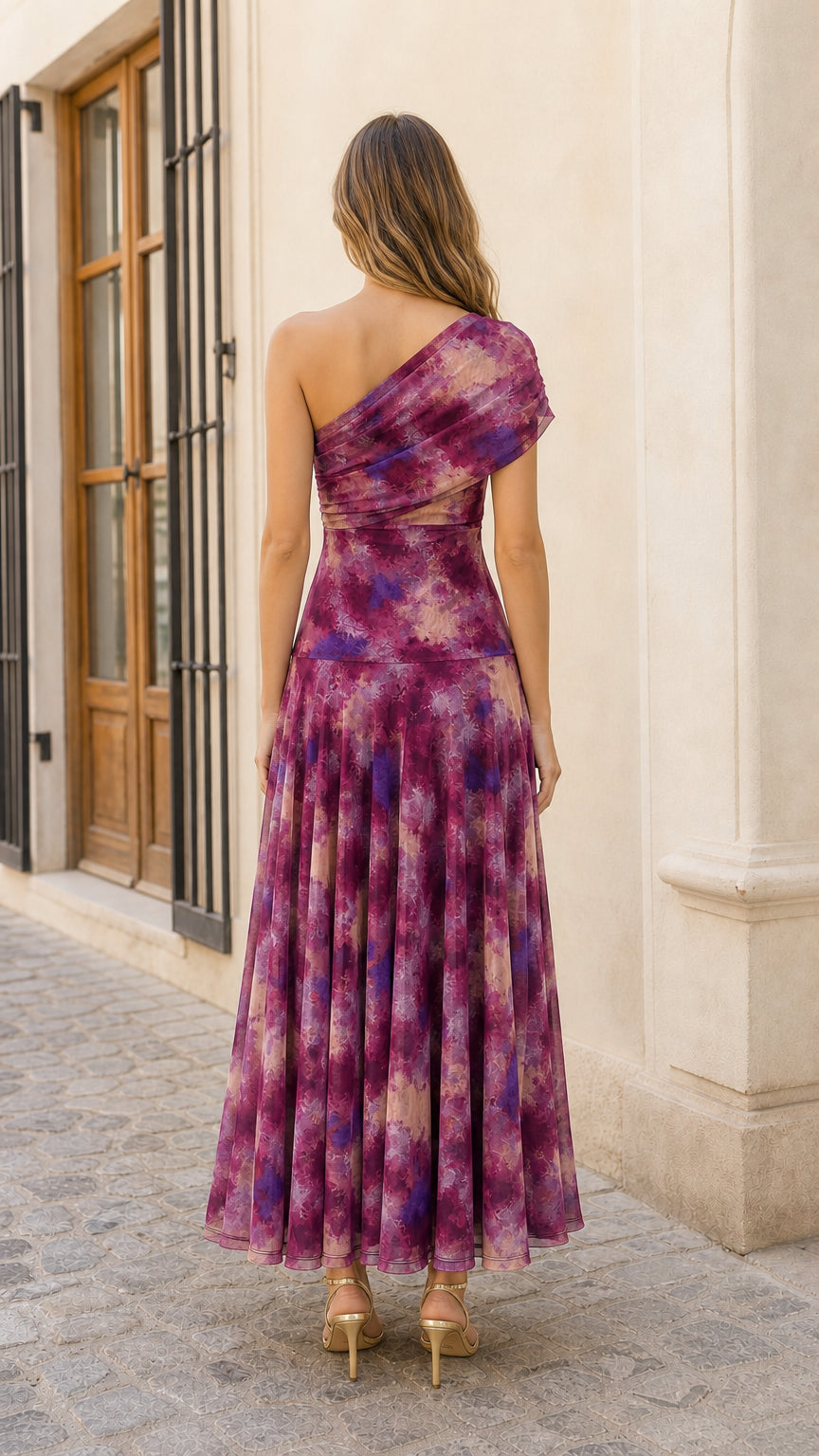 Back view of model showcasing one-shoulder strap and pleated back