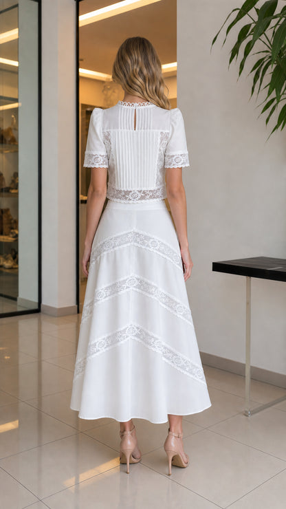 Back view of woman wearing white lace crop top and matching skirt