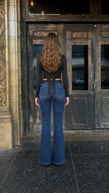 Back view of woman showing self-tie bow detail on black crop top