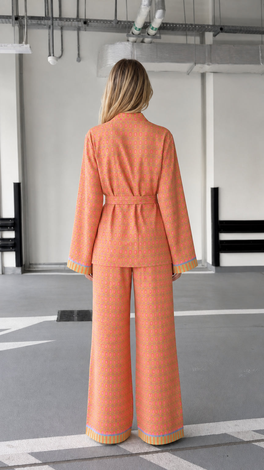 Woman wearing orange patterned two-piece lounge set, back view