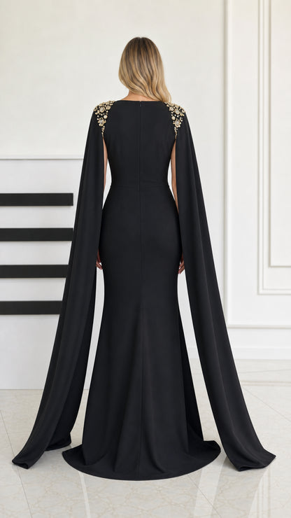 Back view of black formal mermaid gown featuring trailing cape sleeves