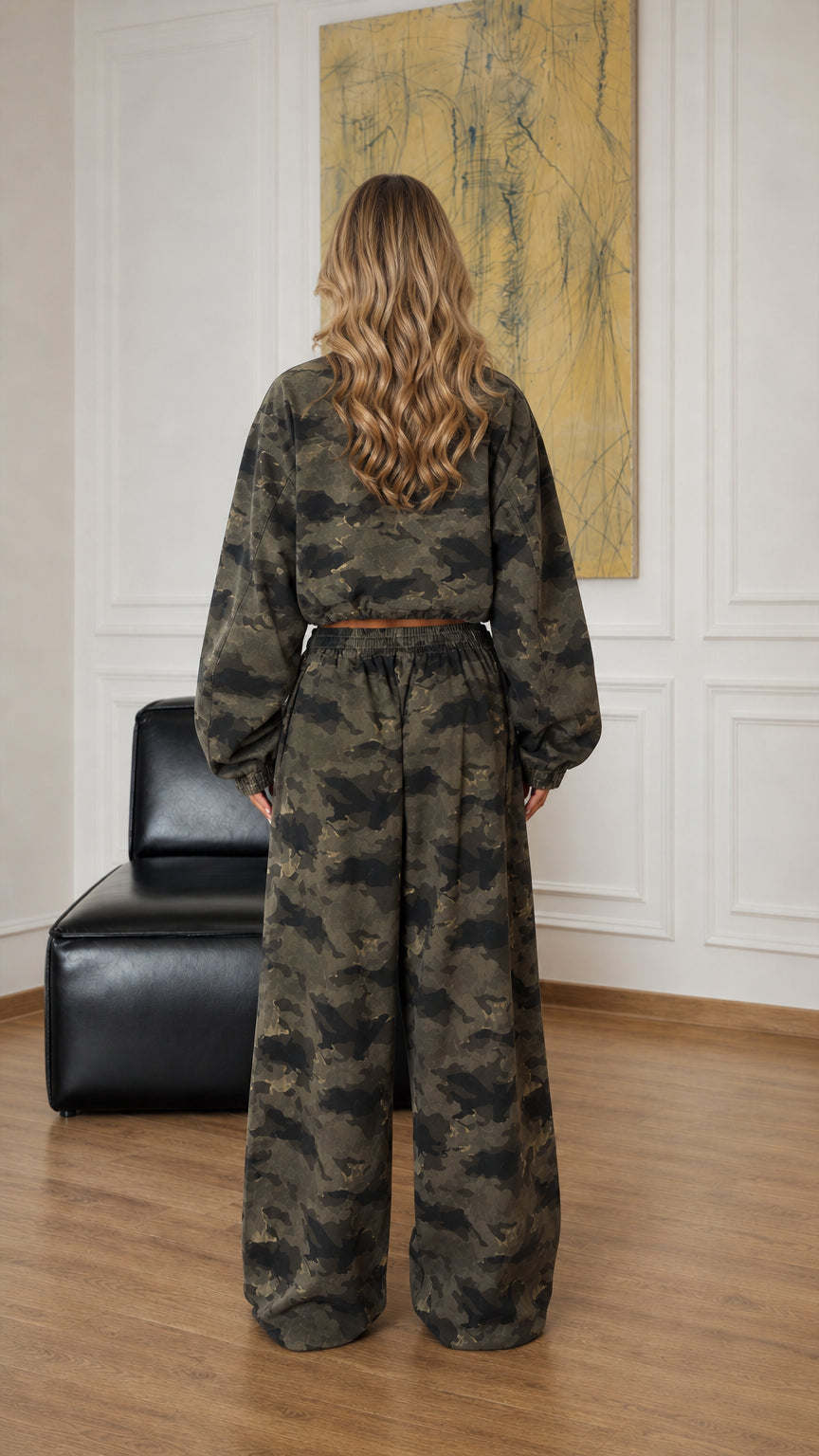 Back view of model wearing army green camouflage cropped jacket and relaxed pants