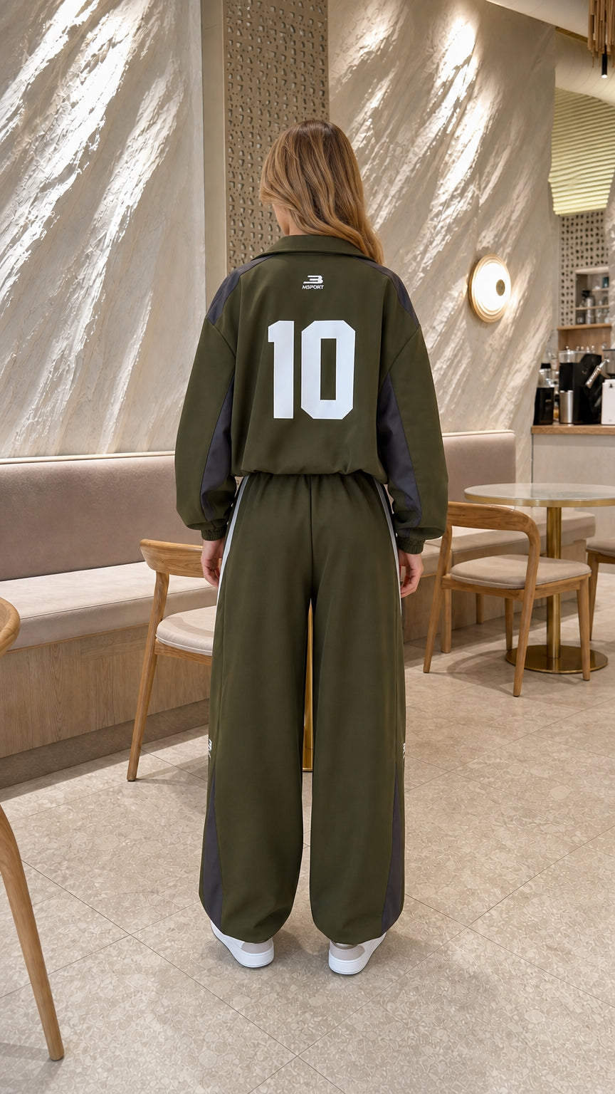 Back view of model in olive green tracksuit jacket showing graphic number 10