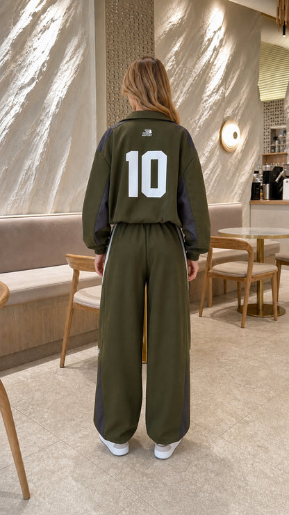 Back view of model in olive green tracksuit jacket showing graphic number 10