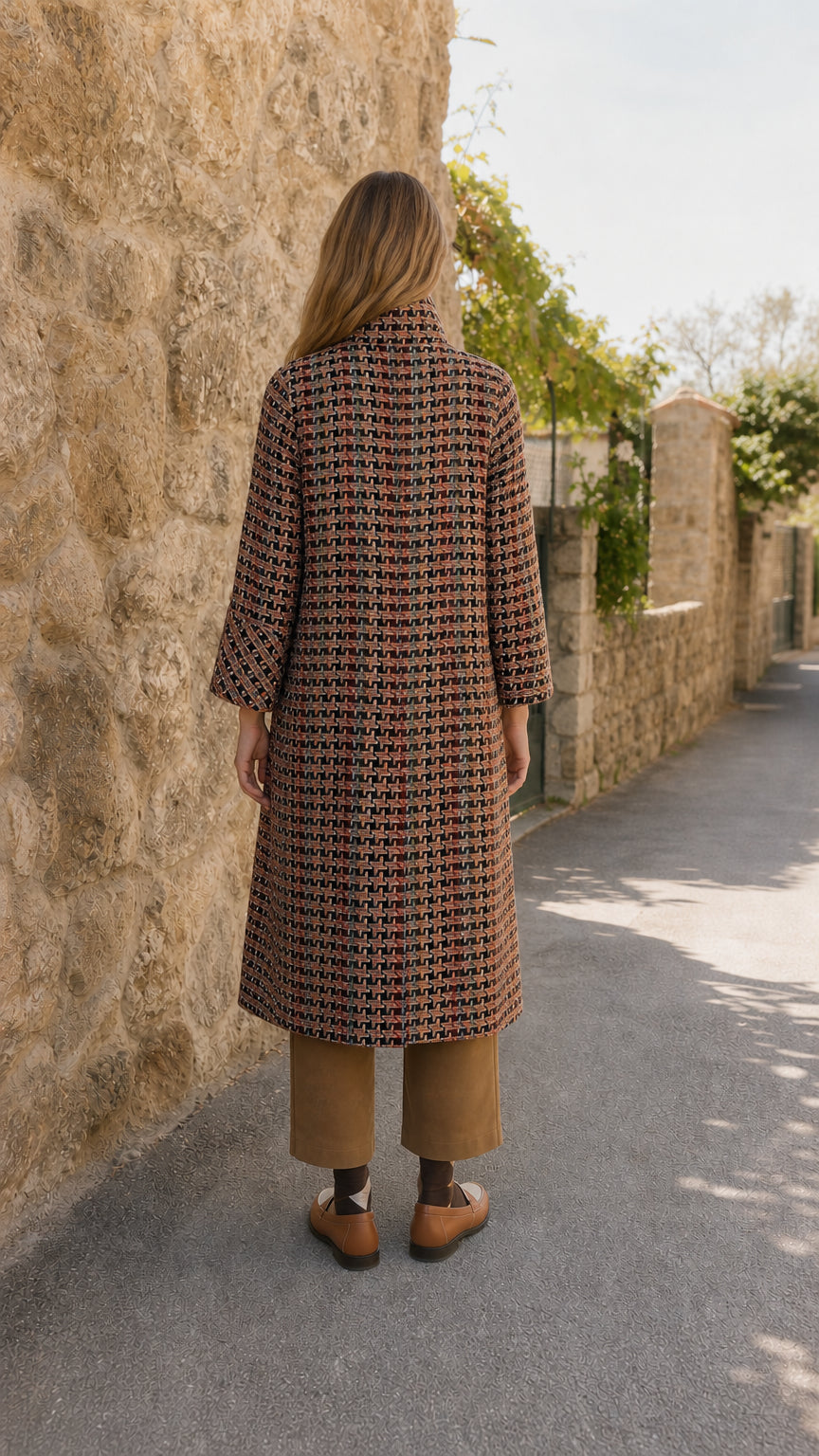 Back view of model showing the longline silhouette of rust multi tweed coat