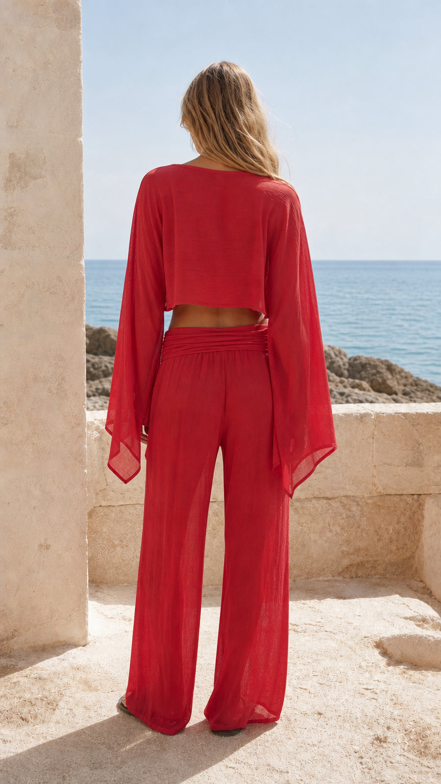 Back view of woman wearing red matching crop top and trousers