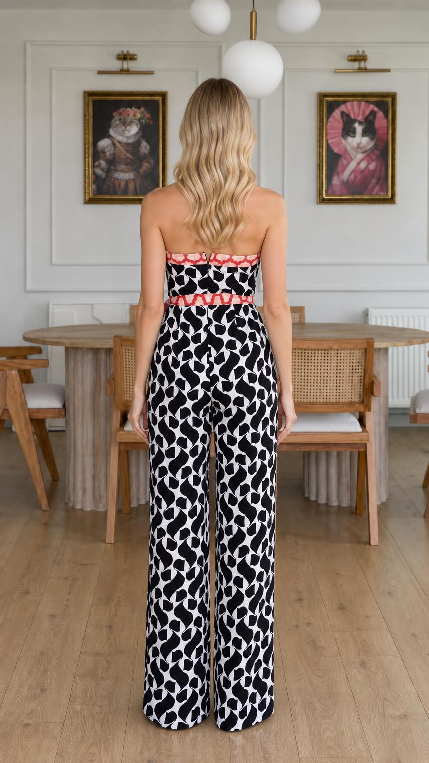 Back view of model wearing black and white abstract print halter jumpsuit