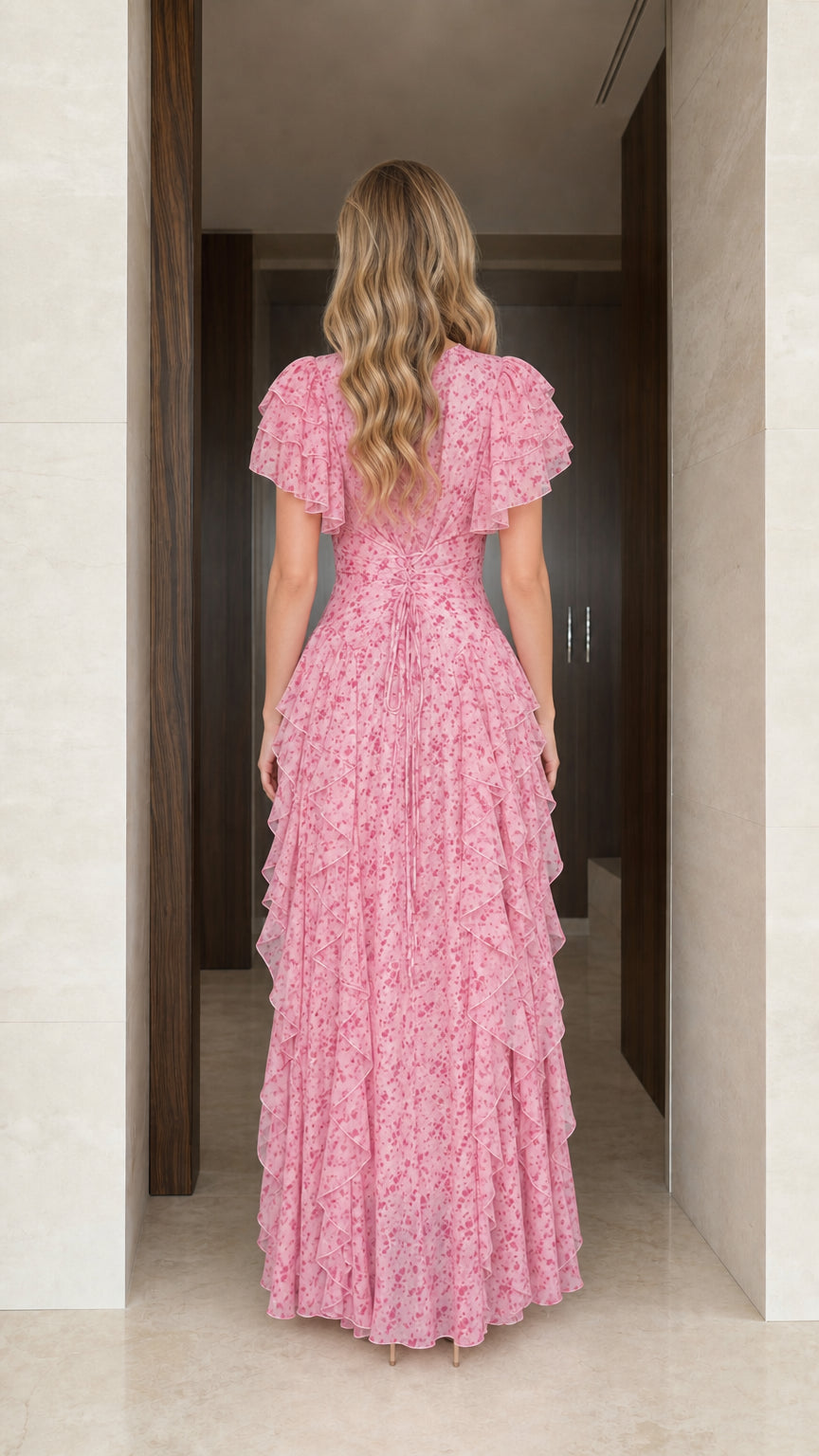 Model wearing pink floral maxi dress, back view