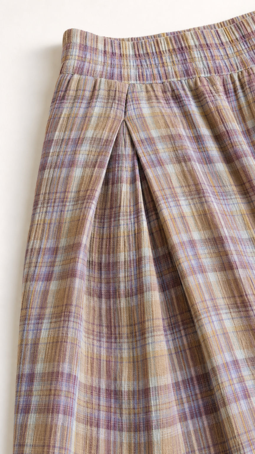 Close-up detail of the elastic waistband and front pleating on plaid lantern pants