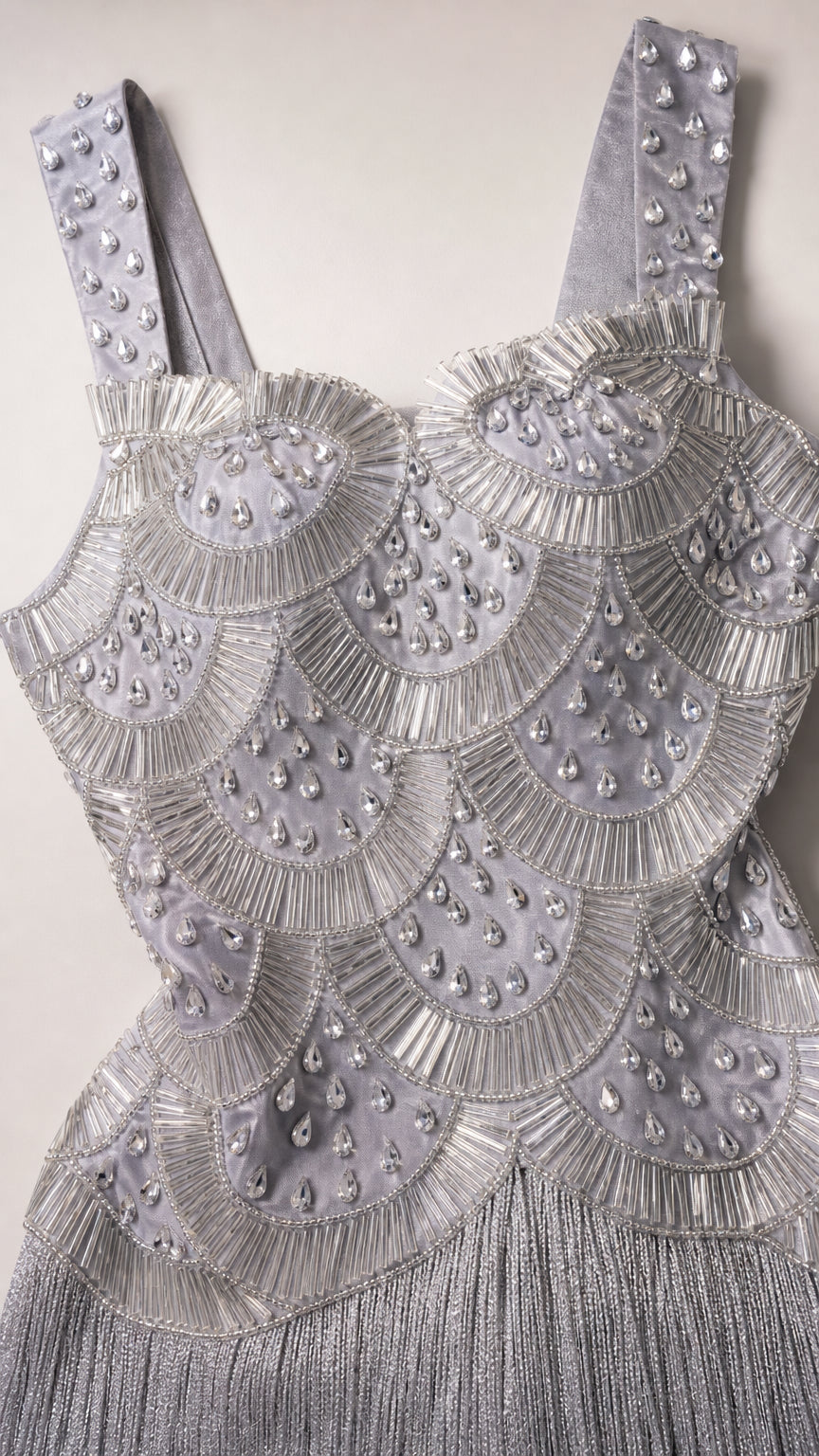 Close-up detail of ornate scallop beadwork and sequin embellishments on silver bodice