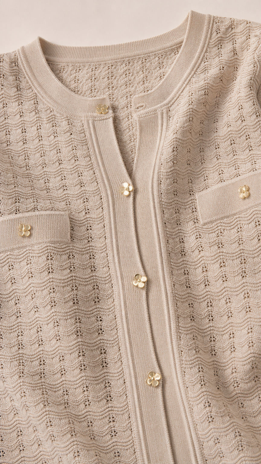 Close-up detail of beige button-front knit top with pockets