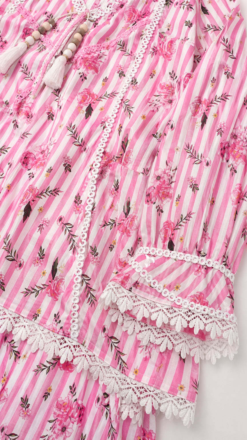 Close-up detail of pink tunic neckline, lace trim, and tassel ties
