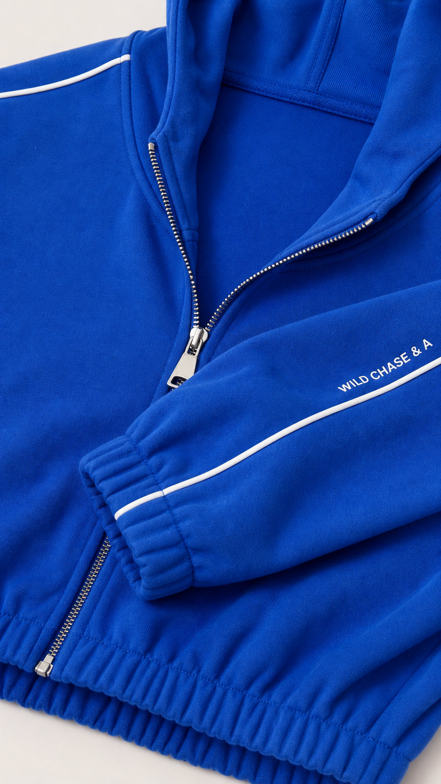Close-up detail of Royal Blue hoodie zipper, ribbed cuff, and contrast white piping