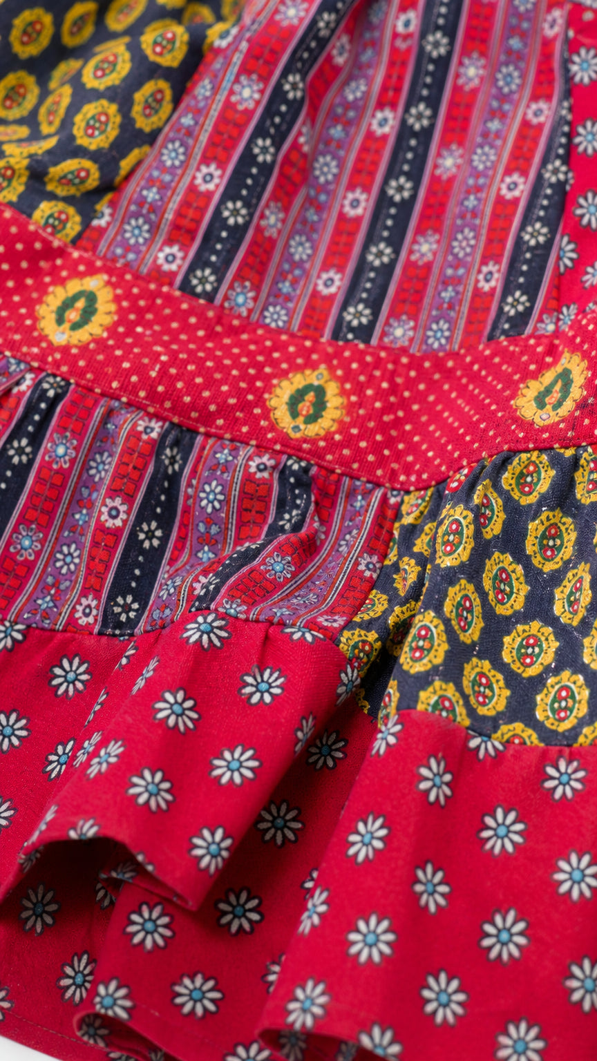 Close-up detail of mixed floral and geometric prints on red dress