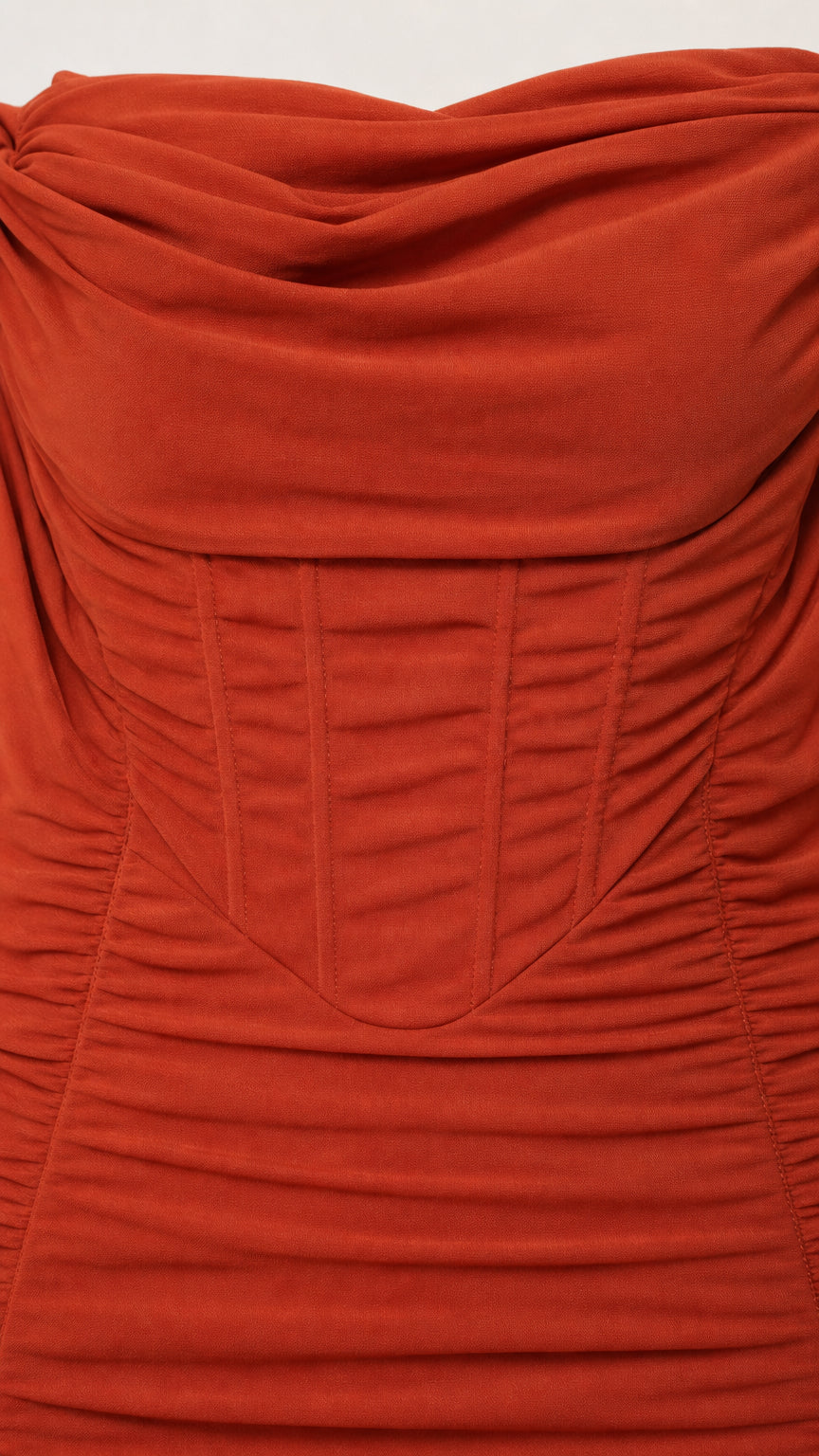 Close-up detail of draped neckline and corset bodice on rust dress