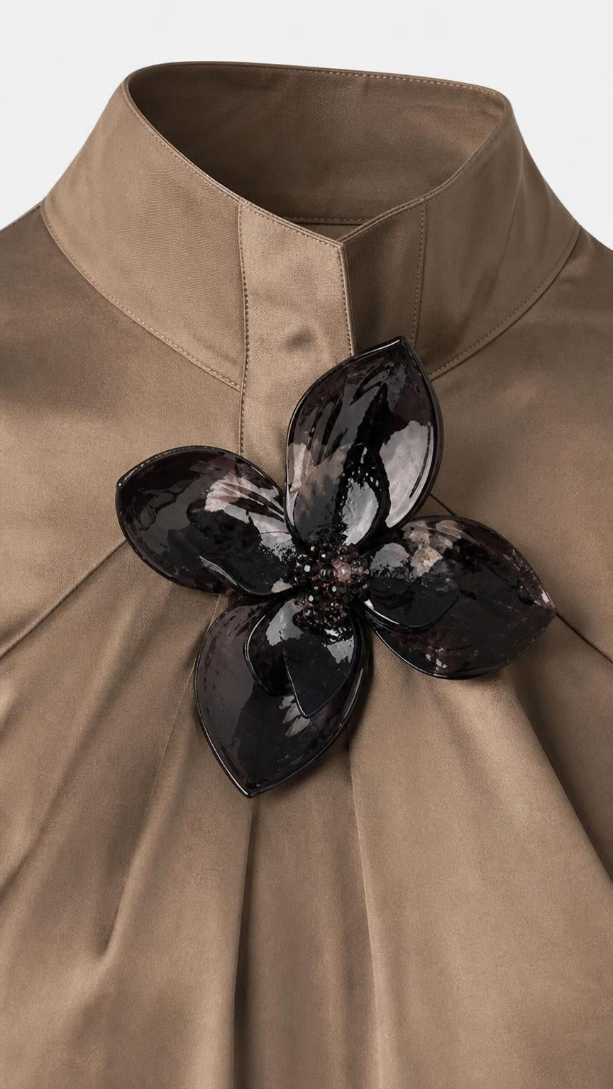 Close-up detail of high collar and glossy black 3D floral applique