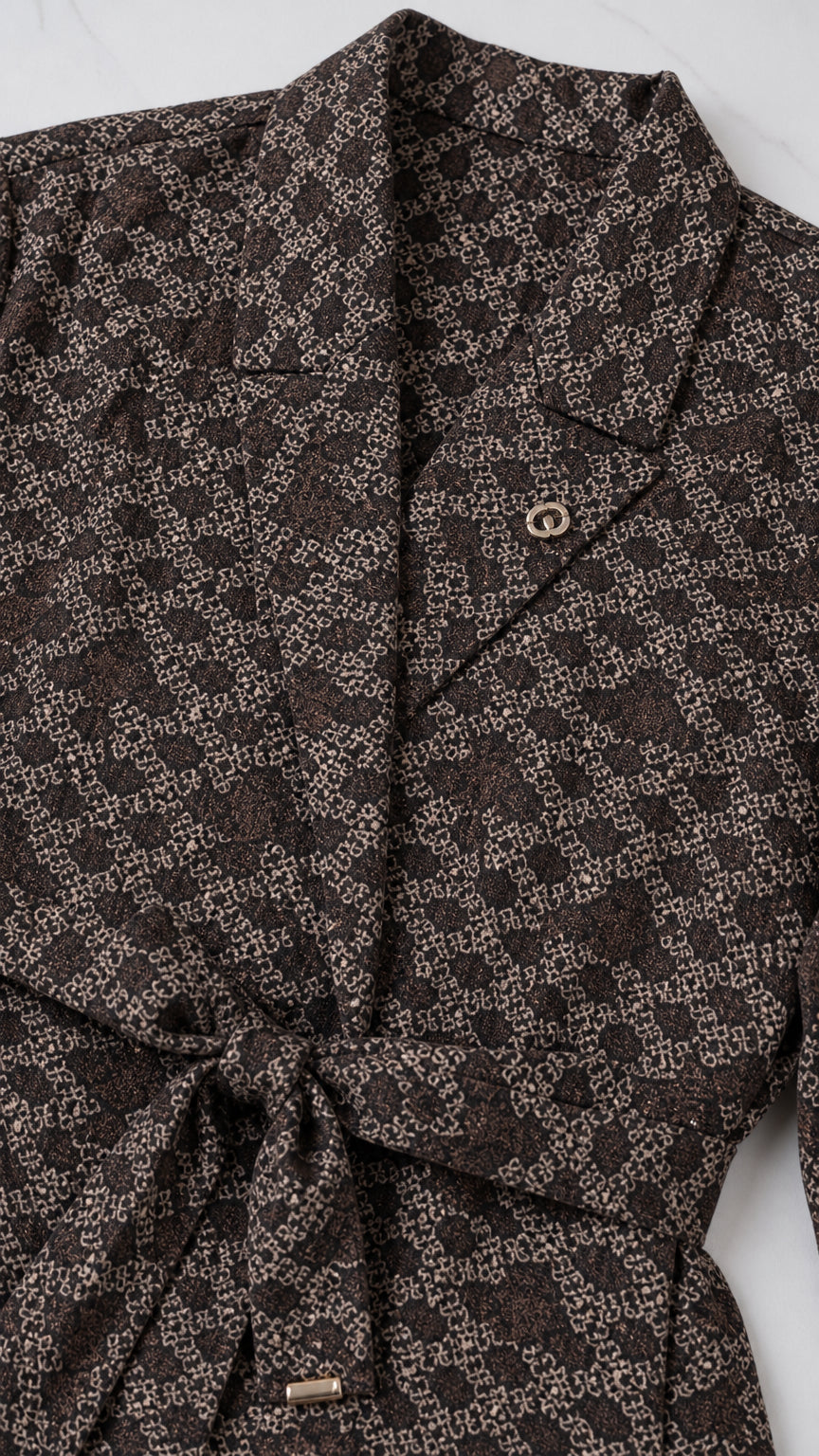 Close-up detail of notch collar, geometric pattern, and tie waist belt on blazer
