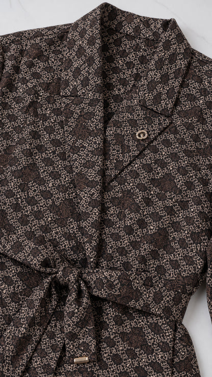 Close-up detail of notch collar, geometric pattern, and tie waist belt on blazer