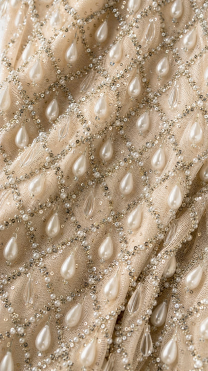 Close-up detail of geometric mesh fabric with pearls and sequins