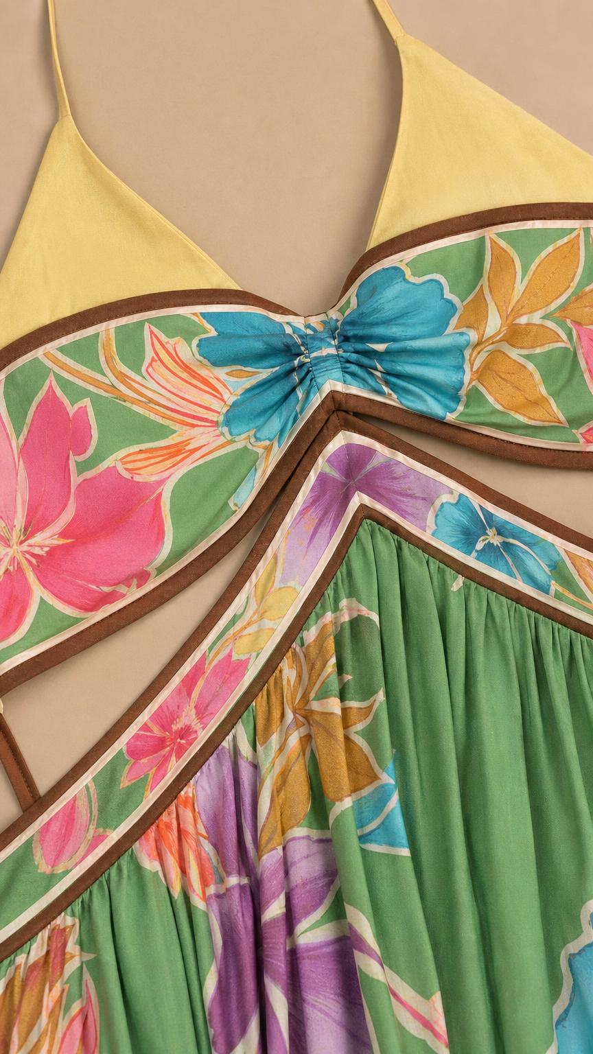 Close-up detail of the bodice, straps, and floral print of the green maxi dress