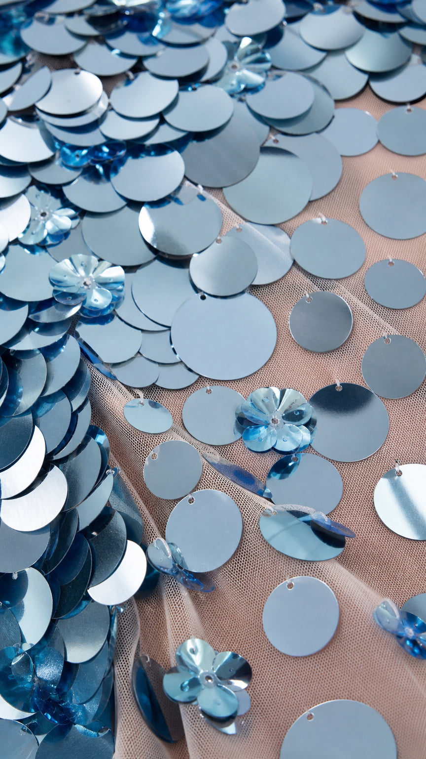 Close-up detail of light blue round sequins and mesh fabric